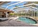 Backyard pool area with screened in enclosure featuring a spa, patio seating, and an outdoor grill area at 2280 Mackenzie Ct, Clearwater, FL 33765