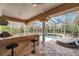 A covered pool area features a bar, ceiling fan, lounge chairs, and tiled flooring at 2280 Mackenzie Ct, Clearwater, FL 33765