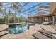 Screened in outdoor pool with heated spa, patio furniture and an outdoor kitchen at 2280 Mackenzie Ct, Clearwater, FL 33765