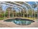 Enclosed pool area with lush landscaping, waterslide, and a calming waterfall feature at 2280 Mackenzie Ct, Clearwater, FL 33765