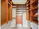 Organized walk-in closet with wooden shelves, drawers, and ample hanging space for storage at 2280 Mackenzie Ct, Clearwater, FL 33765