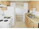 Practical kitchen with wood cabinets, a white refrigerator and stove and views to the living room at 24862 Us Highway 19 N # 2801, Clearwater, FL 33763