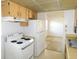 Cozy kitchen featuring wood cabinets, white appliances and views to the living room at 24862 Us Highway 19 N # 2801, Clearwater, FL 33763