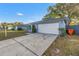 Long concrete driveway leads to a two car garage of single story home at 2552 Bramblewood W Dr, Clearwater, FL 33763