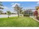 Landscaped backyard offers lush green grass, mature trees, beautiful plantings and views of the water at 2665 Lakebreeze N Ln, Clearwater, FL 33759