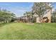 Expansive backyard with lush greenery, screened-in lanai, and beautiful landscaping at 2665 Lakebreeze N Ln, Clearwater, FL 33759