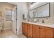 Bathroom with double sinks, stylish mirrors, and warm wood cabinets at 2665 Lakebreeze N Ln, Clearwater, FL 33759