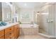 Elegant bathroom featuring a soaking tub, glass shower, and double vanity at 2665 Lakebreeze N Ln, Clearwater, FL 33759
