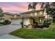 Elegant two-story home featuring a three-car garage, well-manicured lawn, and a beautiful front entrance at 2665 Lakebreeze N Ln, Clearwater, FL 33759