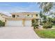 Stunning two-story home with a three-car garage, brick driveway, and meticulous landscaping at 2665 Lakebreeze N Ln, Clearwater, FL 33759