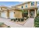 Home featuring a beige exterior, paver driveway, two-car garage and manicured landscaping at 2665 Lakebreeze N Ln, Clearwater, FL 33759