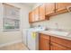 Functional laundry room with storage cabinets, sink, countertop space and a window for natural light at 2665 Lakebreeze N Ln, Clearwater, FL 33759