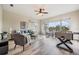 Bright living room features wood floors, large windows with views, a ceiling fan, and a comfortable seating area at 2665 Lakebreeze N Ln, Clearwater, FL 33759