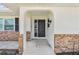 Welcoming front entrance featuring an arched doorway, modern light fixture and the appealing decorative brick facade at 269 Algiers Dr, Venice, FL 34293