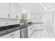 Modern kitchen featuring white cabinets, dark countertops, and stainless steel appliances, offering a sleek cooking space at 269 Algiers Dr, Venice, FL 34293