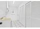 Utility room with a laundry sink, storage cabinets, and access to the backyard at 269 Algiers Dr, Venice, FL 34293