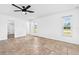 Empty main bedroom featuring a ceiling fan, tile flooring, and an en-suite bathroom at 269 Algiers Dr, Venice, FL 34293