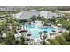 Stunning community pool featuring ample lounge seating, lush tropical landscaping and a clubhouse in the background at 29845 Imperati Blvd, Wesley Chapel, FL 33543