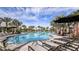 Spacious community pool with comfortable lounge chairs and tropical landscaping at 29845 Imperati Blvd, Wesley Chapel, FL 33543