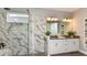Modern bathroom featuring marble-style tile shower and double sink vanity at 29863 Imperati Blvd, Wesley Chapel, FL 33543
