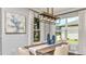 Dining room with modern light fixture, table seating, and large bright windows at 29863 Imperati Blvd, Wesley Chapel, FL 33543