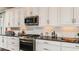 Bright kitchen features white cabinets, stainless steel appliances, and stylish backsplash at 29863 Imperati Blvd, Wesley Chapel, FL 33543