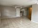 Open-concept living room with neutral tile flooring, ceiling fans, and access to the kitchen at 3112 E 8Th Ave, Tampa, FL 33605