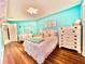 Bright bedroom with wood floors, turquoise walls, and white furniture at 3358 Tanglewood Trl, Palm Harbor, FL 34685