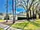Exterior side view of home showcasing the two-car garage and mature trees for shade at 3358 Tanglewood Trl, Palm Harbor, FL 34685
