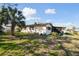 Backyard features a modest lawn, mature palm tree, and a glimpse of the house's exterior at 4002 W Gray St, Tampa, FL 33609