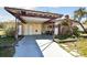 A tan single-story house with a covered carport and a brick chimney at 4002 W Gray St, Tampa, FL 33609