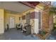 View of covered porch area with seating at a single-story home with brick accents at 4002 W Gray St, Tampa, FL 33609