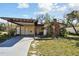 Charming single-story home featuring a carport, brick chimney and quaint front yard at 4002 W Gray St, Tampa, FL 33609