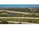 Aerial shot showcasing a wide highway running beside a community, near a small pond, connecting residents to city amenities at 4535 Kennewick Pl, Riverview, FL 33578