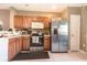 Well-lit kitchen featuring wood cabinetry, stainless steel appliances, and a tile floor at 4535 Kennewick Pl, Riverview, FL 33578