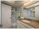 Bathroom with granite countertops, white cabinets, and decorative shower curtain at 4904 38Th S Way # 316, St Petersburg, FL 33711