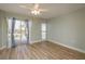 Bright bedroom featuring wood flooring, a ceiling fan and sliding glass doors to a balcony at 4904 38Th S Way # 316, St Petersburg, FL 33711