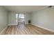 Bright living room featuring wood floors, light blue walls, and natural light from a sliding glass door at 4904 38Th S Way # 316, St Petersburg, FL 33711