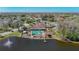 Overhead view shows the community pool, a clubhouse, pier, and picturesque lake at 4955 Grist Mill Cir, New Port Richey, FL 34655