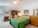Comfortable bedroom featuring a ceiling fan, a large bed, and a cozy study area at 4955 Grist Mill Cir, New Port Richey, FL 34655