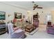 Inviting living room featuring a floral sofa, comfortable armchairs, and a ceiling fan at 4955 Grist Mill Cir, New Port Richey, FL 34655