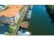 Aerial view featuring canal-front condos, boat docks, a wooden patio, palm trees, and assigned parking spaces at 5000 Culbreath Key Way # 1-310, Tampa, FL 33611