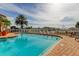 Community pool area with a palm tree, brick paving, lounge chairs, and a fence overlooking the harbor at 5000 Culbreath Key Way # 1-310, Tampa, FL 33611