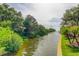 Scenic waterfront view with lush green trees, a tranquil canal, and picturesque palm trees along the shore at 5000 Culbreath Key Way # 1-310, Tampa, FL 33611