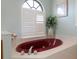 Bathroom featuring red bathtub with white shutters on window and light blue walls at 5140 Eclipse Ct, Spring Hill, FL 34607