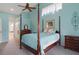 Beautiful bedroom featuring a four-poster bed, ceiling fan, light blue walls, and stylish decor at 5140 Eclipse Ct, Spring Hill, FL 34607
