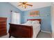Charming bedroom featuring a ceiling fan, with light blue walls and stylish decor at 5140 Eclipse Ct, Spring Hill, FL 34607