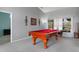 Bright game room has a pool table, soft carpet, and decor on the gray walls at 5140 Eclipse Ct, Spring Hill, FL 34607