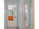 Hallway view with doorways to bathroom and a shower room, with light blue walls and grey carpet at 5140 Eclipse Ct, Spring Hill, FL 34607