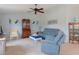 Cozy living room featuring a ceiling fan, blue sofa, and stylish decor at 5140 Eclipse Ct, Spring Hill, FL 34607